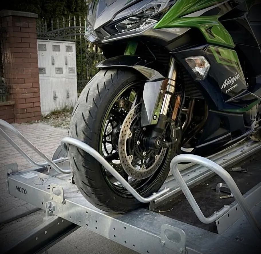 Przednie koło motocykla Kawasaki Ninja w kołysce najazdowej przyczepki MotoPaka