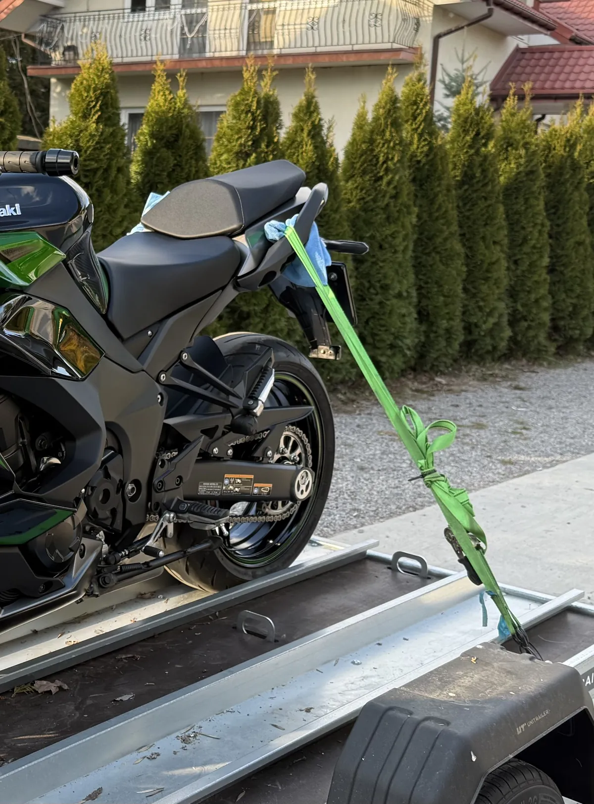 Tylny pas transportowy zapięty za ramę pasażera motocykla Kawasaki i napięty do uchwytu przyczepy