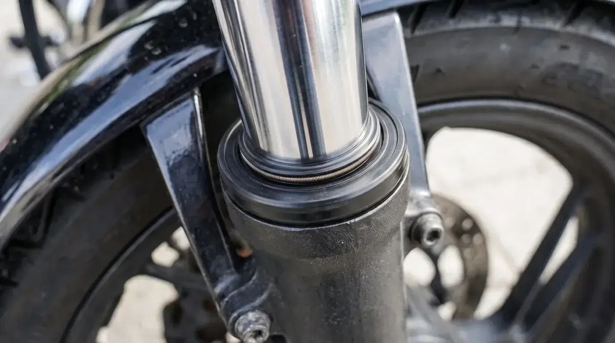 Zbliżenie na przednią lagę motocykla i suchy uszczelniacz bez śladów wycieku oleju