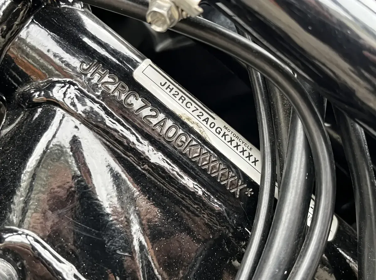 Numer VIN wybity na główce ramy motocykla obok naklejki z tym samym numerem